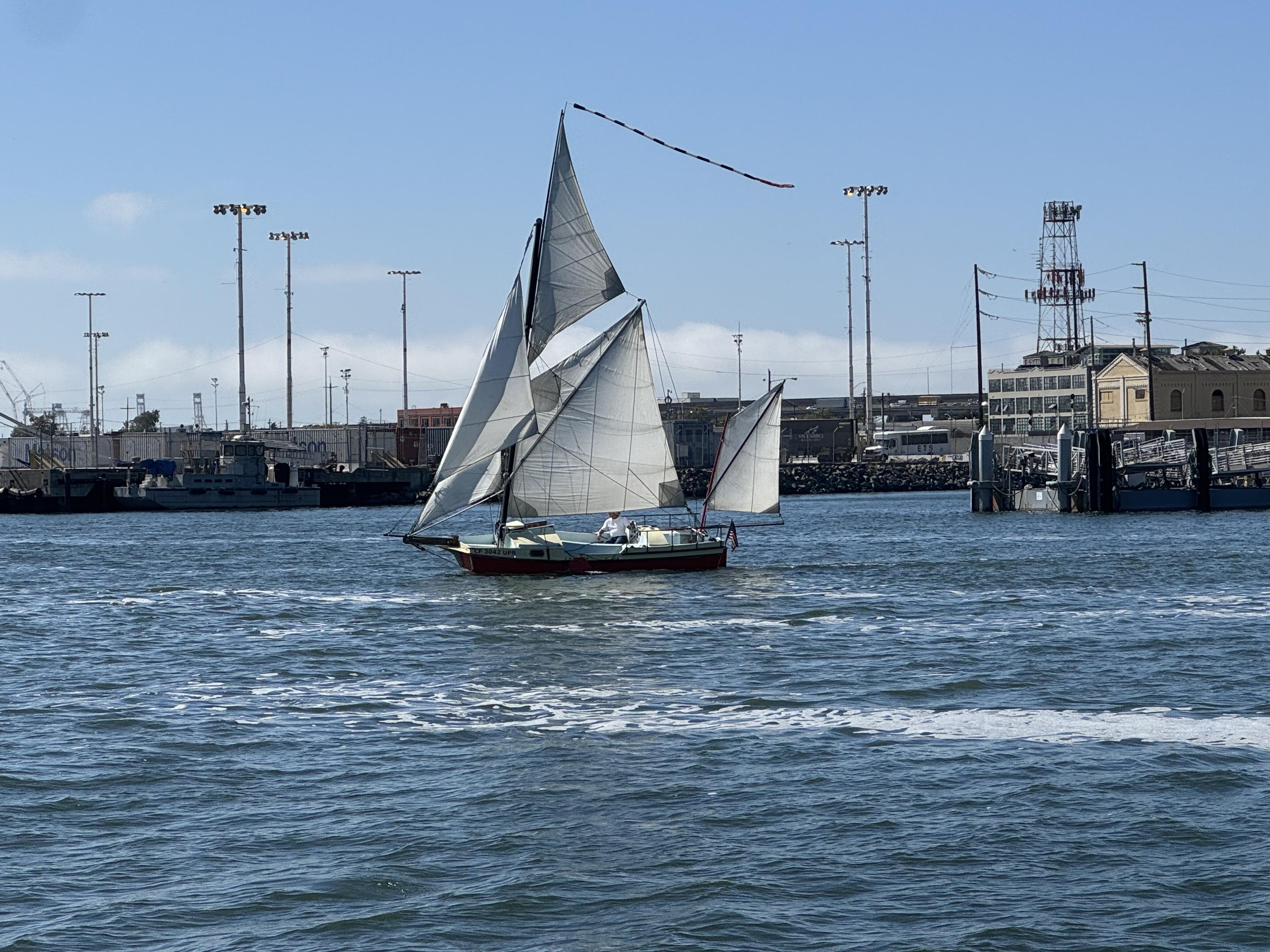 An odd but beautiful boat on the Oakland estuary. Yawl rig with a square bow and bowsprit, sprit rigged main and mizzen, two headsails and a topsail, with a long pennant to top it off.